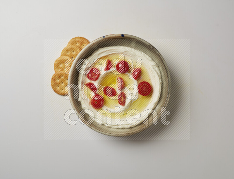 Lebnah garnished with cherry tomato in a grey pottery plate on a white background