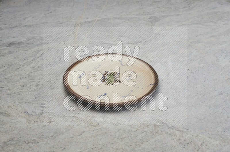 A decorative pottery plate on grey marble background