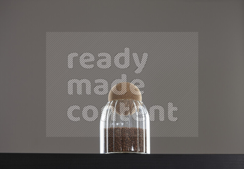 Brown lentils in a glass jar on black background
