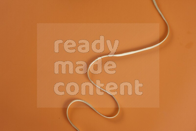 مجموعة من أدوات الخياطة والتفصيل خضراء وبرتقالية اللون على خلفية برتقالية