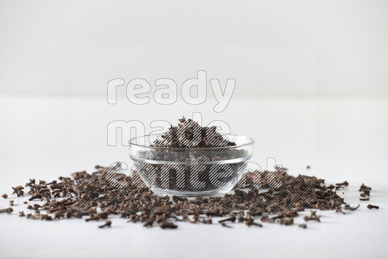 A glass bowl full of cloves on a white flooring