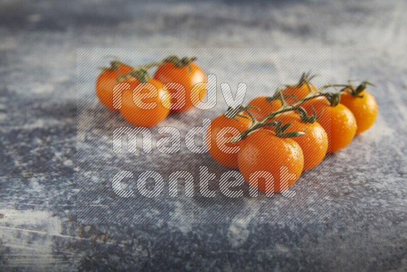 Orange cherry tomato vein on a textured rusty blue background 45 degree
