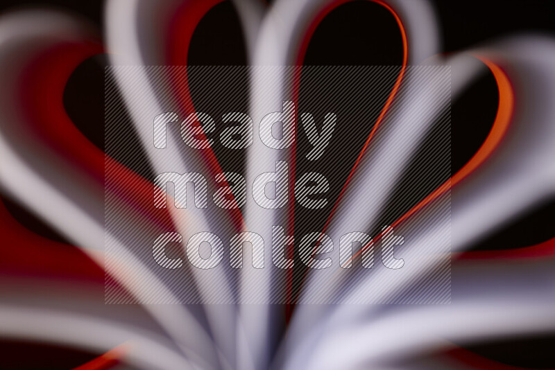 An abstract art piece displaying smooth curves in white and orange gradients created by colored light