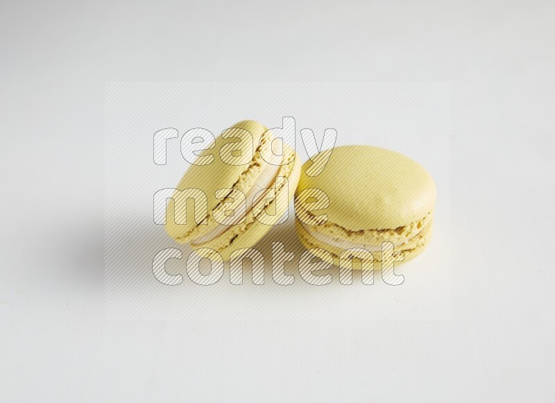 45º Shot of two Yellow Lime macarons on white background