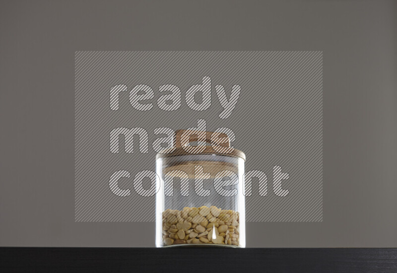 Crushed beans in a glass jar on black background