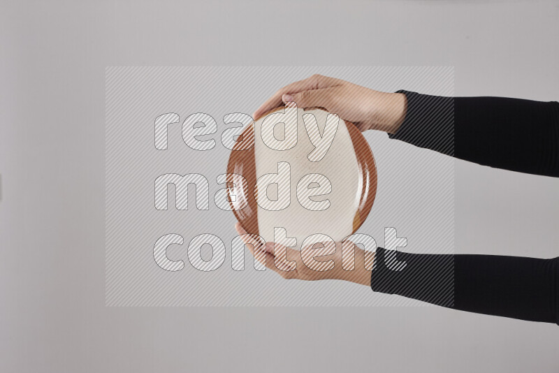 A woman in black abaya holding different pottery essentials in different positions