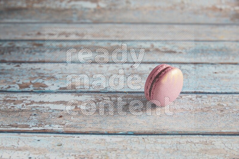 45º Shot of Purple Strawberry macaron on light blue wooden background