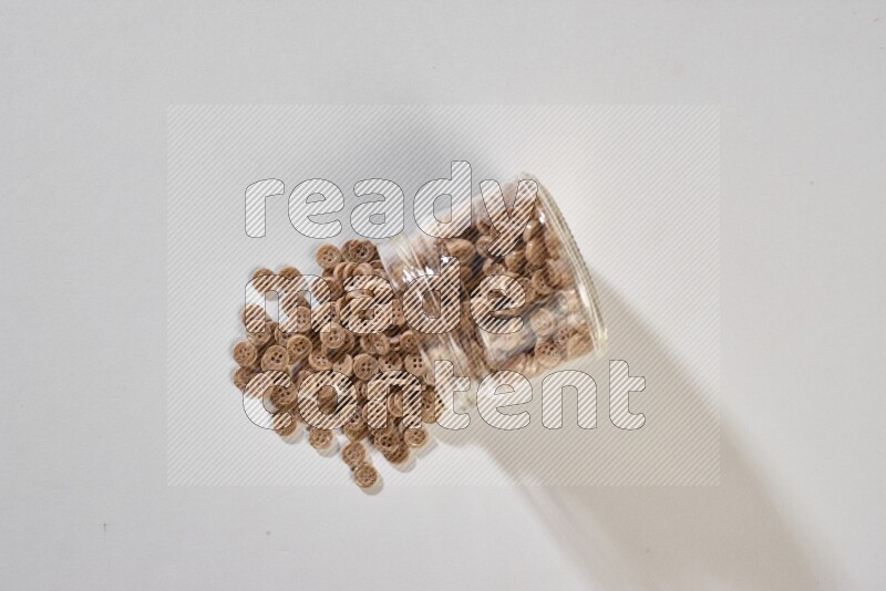 Colored buttons in a glass jar on grey background