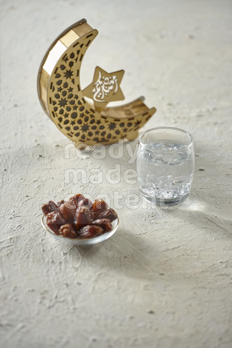 A wooden golden crescent lantern with different drinks, dates, nuts, prayer beads and quran on white background