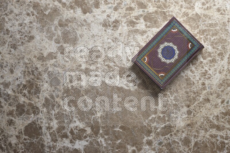 The holy Quran on beige marble background