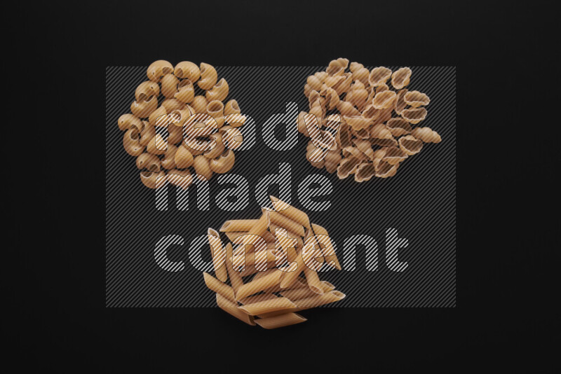 Different pasta types in bunches on black background