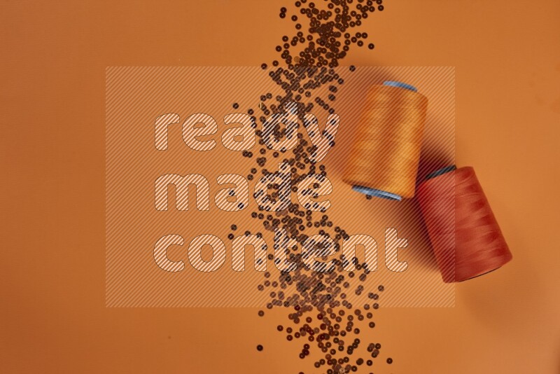 An orange collection of sewing and tailoring tools arranged on a orange background