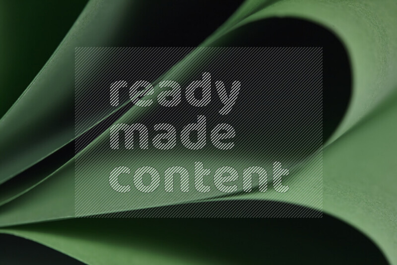 An abstract art showing green paper sheets arranged in an overlapping curves