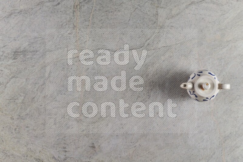 إبريق شاي فخاري على خلفية من الرخام الرمادي