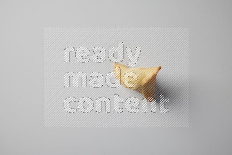 One fried sambosa from a top angle on a white background
