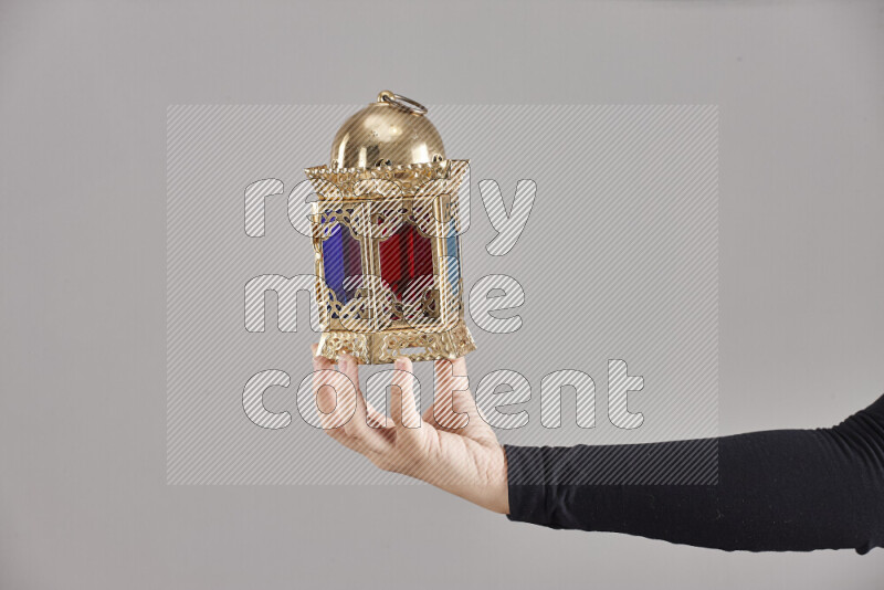 A woman in black abaya holding different ramadan lanterns in different positions