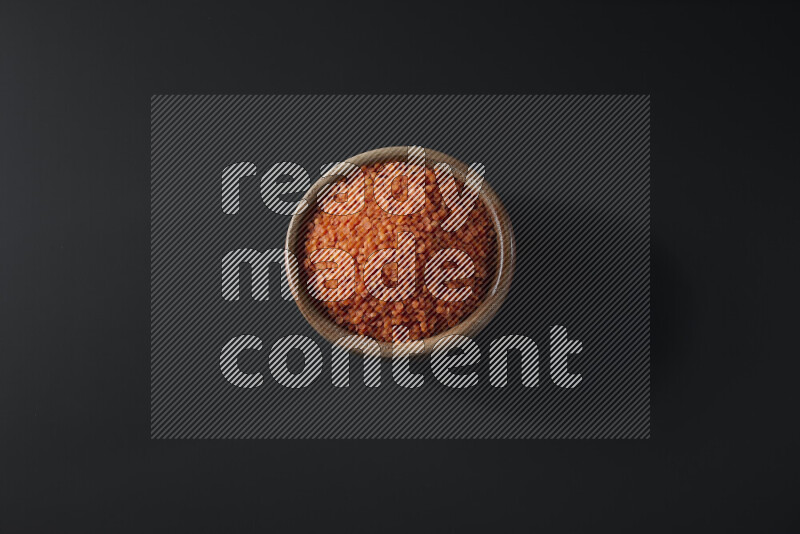 Lentils in a wooden bowl on grey background