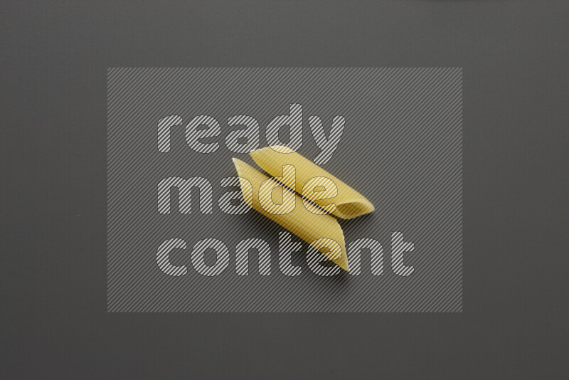 Penne pasta on grey background
