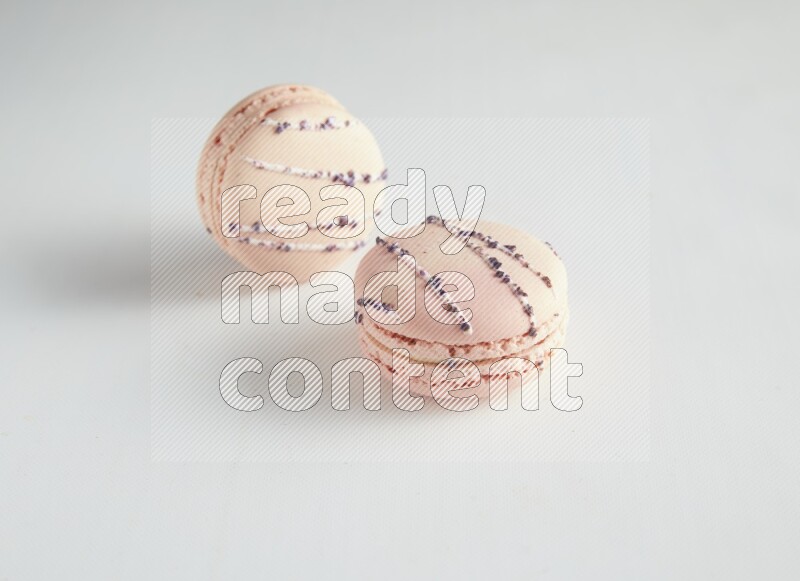 45º Shot of two pink orange blossom macarons on white background