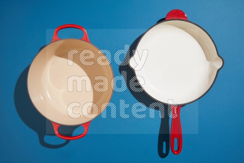 red and white pan and pot on blue background