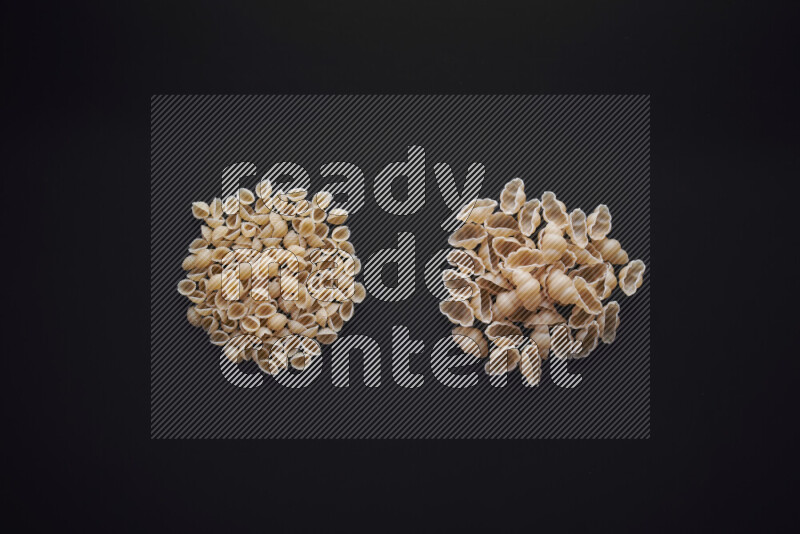 Different pasta types in bunches on black background