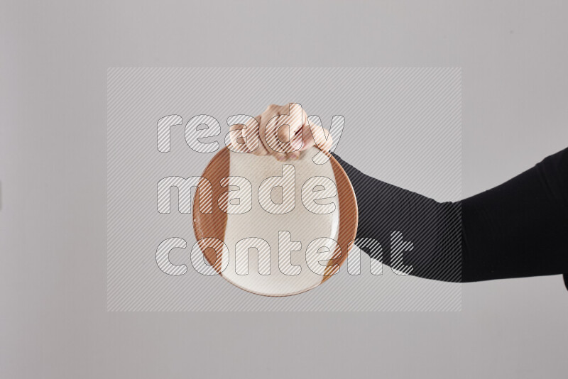 A woman in black abaya holding different pottery essentials in different positions