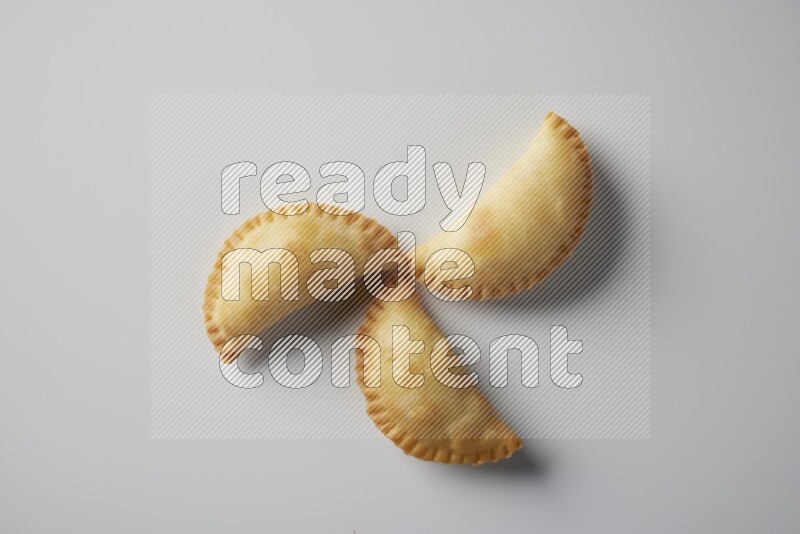 Three fried sambosa from a top angle on a white background