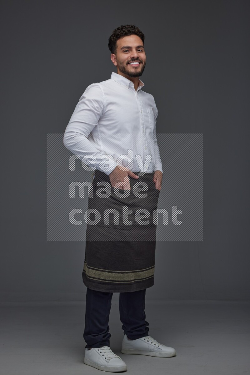 A man wearing smart casual and apron standing and making multi poses eye level on a gray background