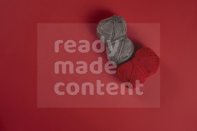 A brown and red collection of sewing and tailoring tools arranged on a red background