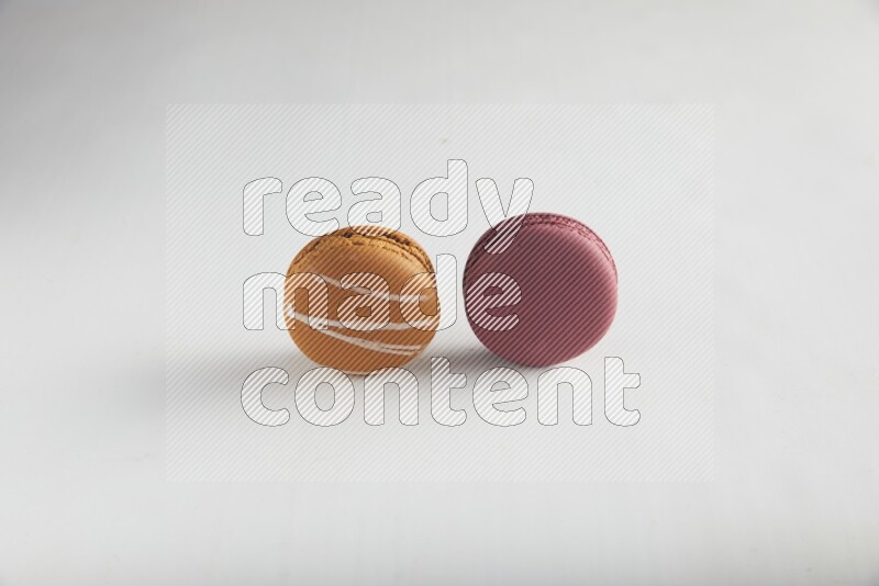 45º Shot of of two assorted Brown Irish Cream, and Red Cherry macarons on white background