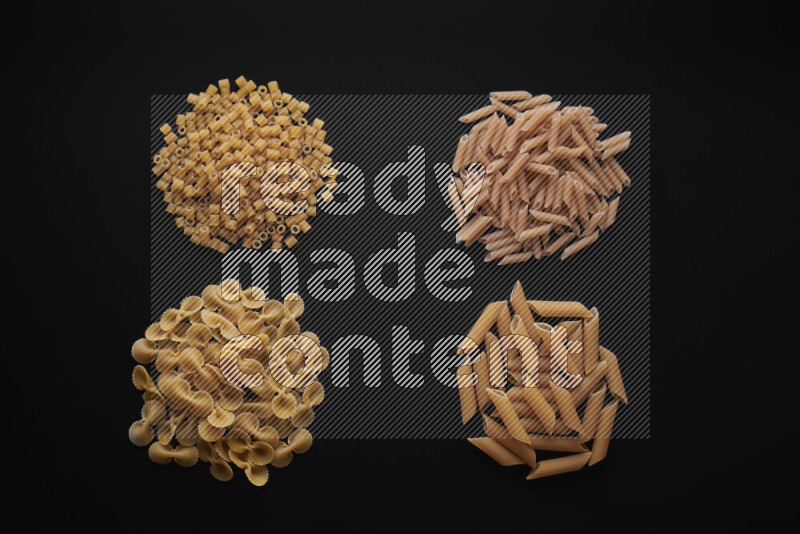 Different pasta types in bunches on black background