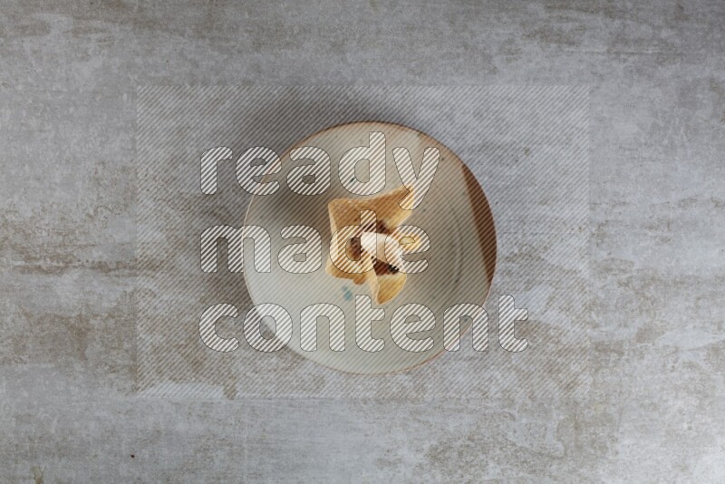 wonton cups with soy sauce ramkin on multi colored pottery on grey textured counter top