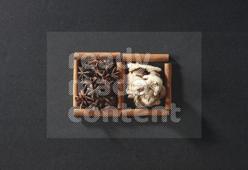 2 squares of cinnamon sticks full of star anise and dried ginger on black flooring