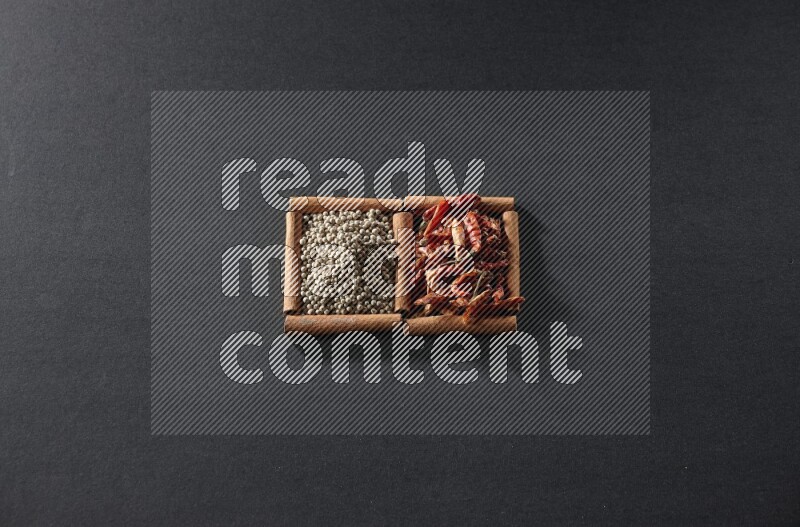 2 squares of cinnamon sticks full of chilis and white peppers on black flooring