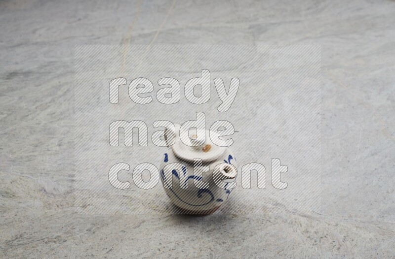 A pottery teapot on grey marble background