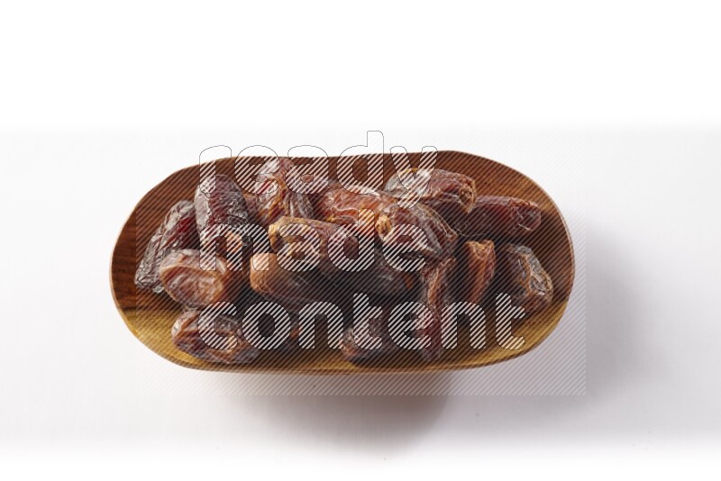 Dates in a wooden plate on white background