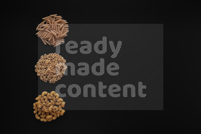 Different pasta types in 3 bunches on black background