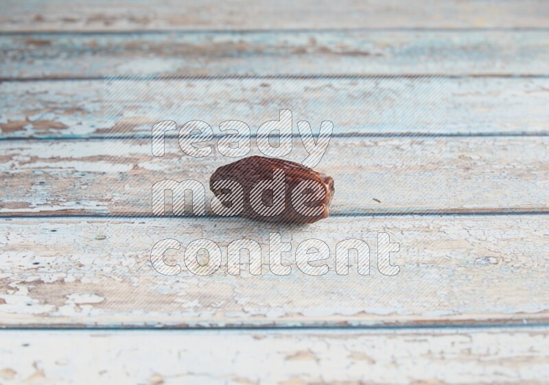 one madjoul date on a light blue wooden background