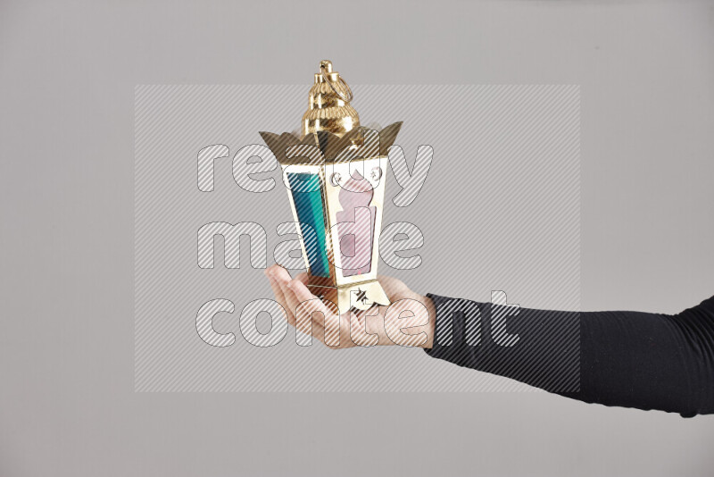 A woman in black abaya holding different ramadan lanterns in different positions