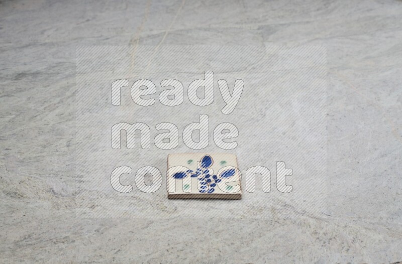 Top view shot of a pottery coaster\ tile on beige marble flooring