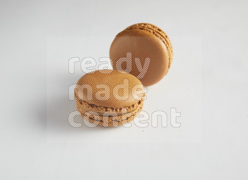 45º Shot of two Brown Maple Taffy macarons on white background