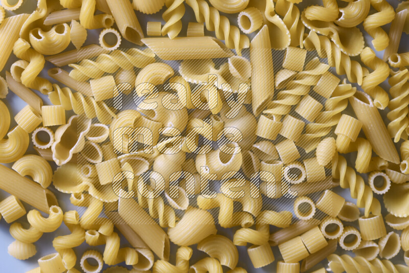 Different pasta types on light blue background
