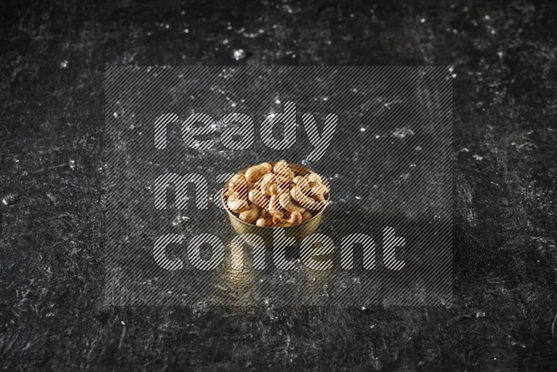 Nuts in a metal bowl in a dark setup