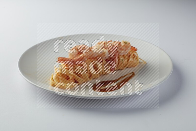 Fettuccini red sauce pasta with shrimp in a white plate on a white background