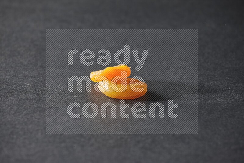 Two dried apricots on a black background in different angles