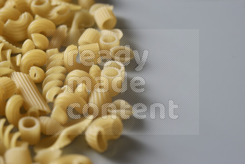 Different pasta types on light blue background