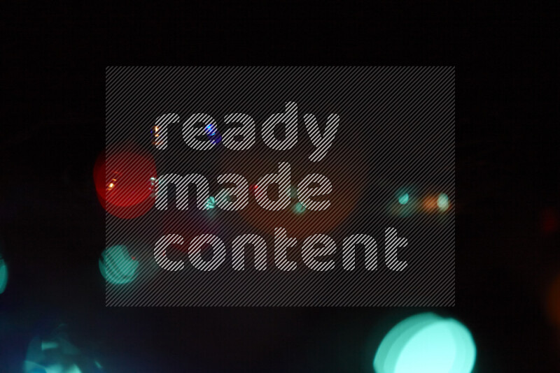 Light bulbs glowing against backdrop of multicolord bokeh