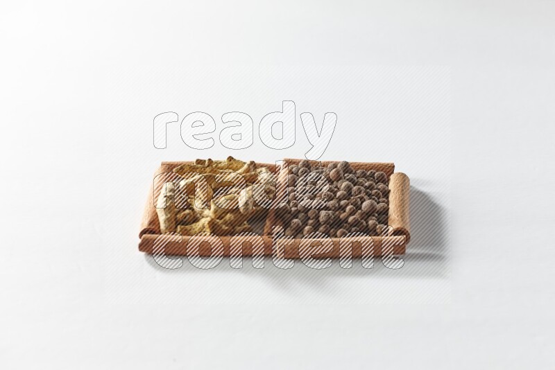 2 squares of cinnamon sticks full of allspice and turmeric fingers on white flooring