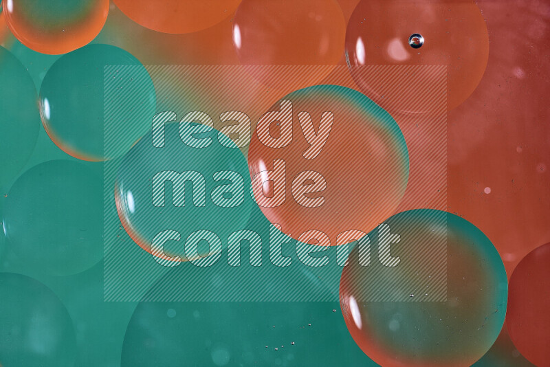 لقطات مقربة لفقاعات من الزيت على سطح الماء باللون الأخضر والبرتقالي