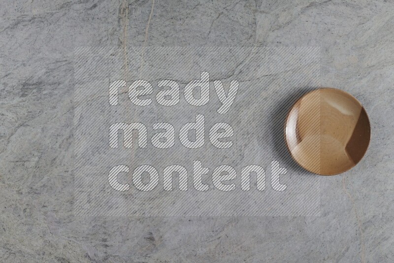 A multicolored pottery plate on grey marble background